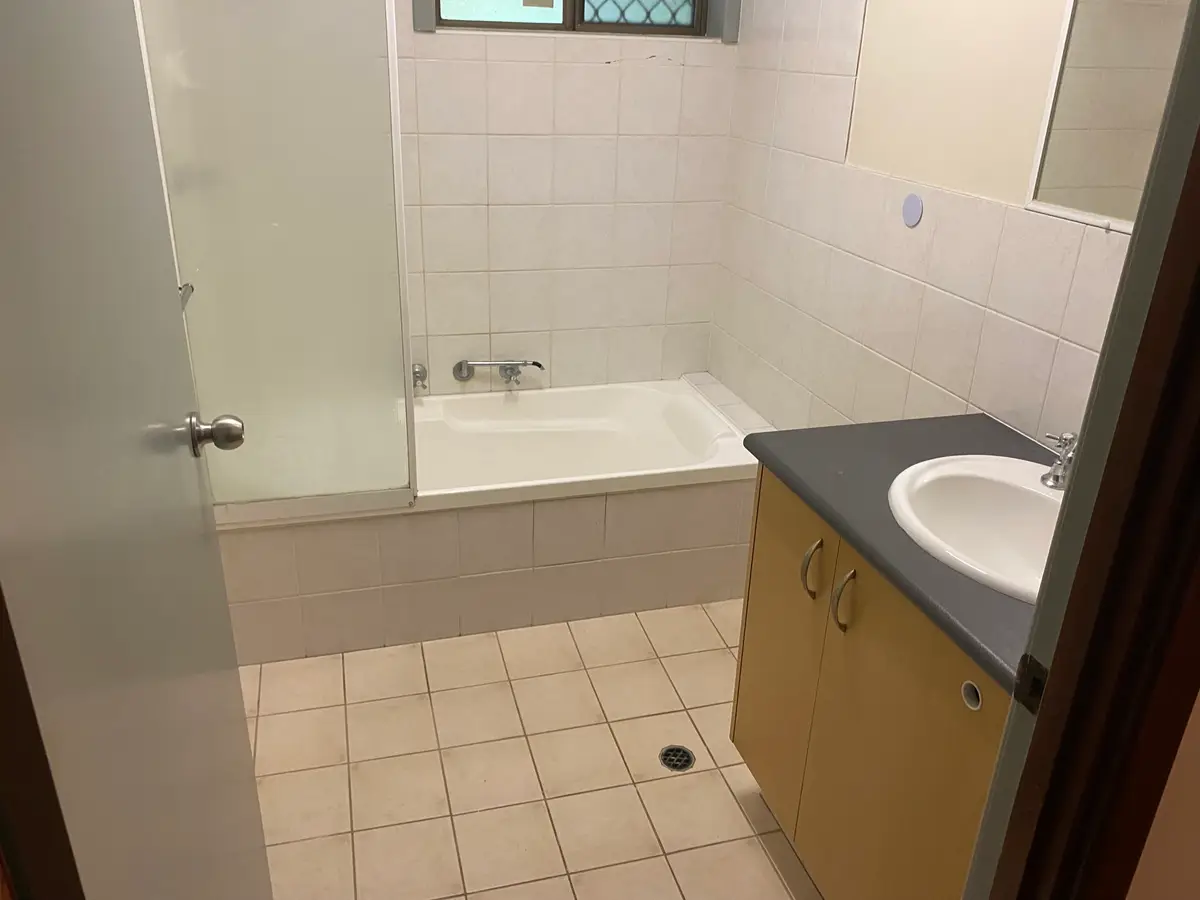 Before: the Midland bathroom with the shower over a bath, a framed screen, and a separate vanity with a gap between them