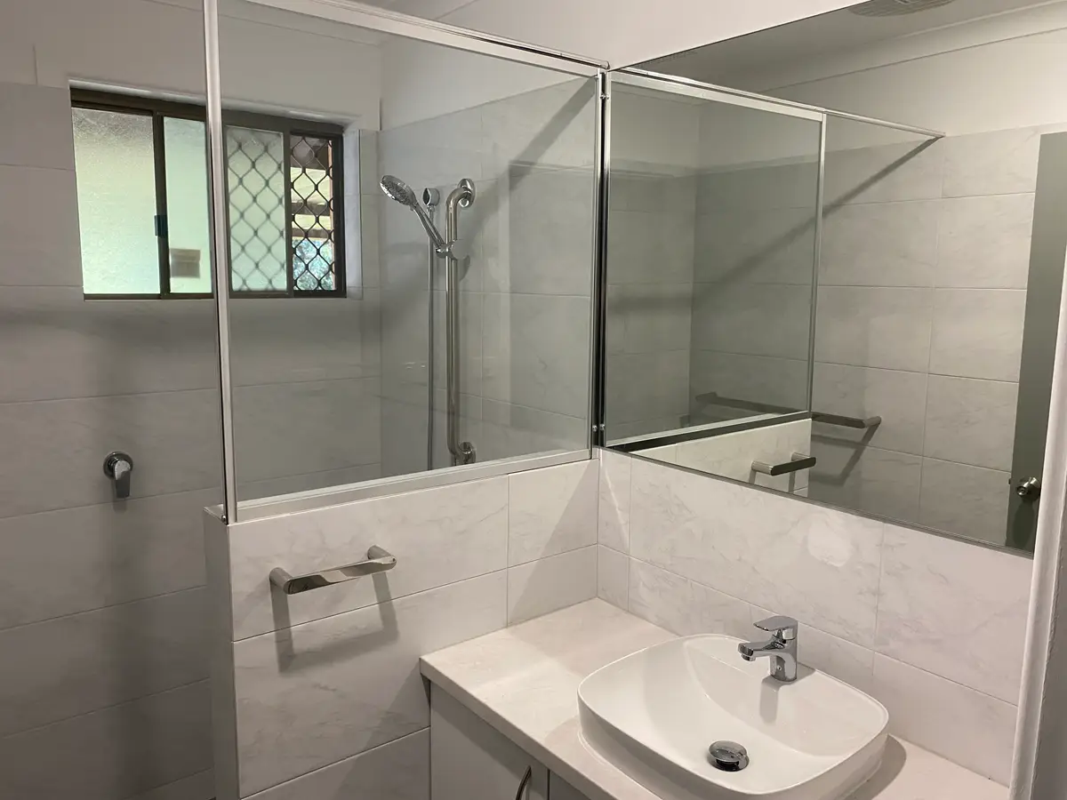 After: the Midland bathroom with a walk-in shower behind a glass panel and nib wall, a hand shower on a rail, and the new vanity beside it