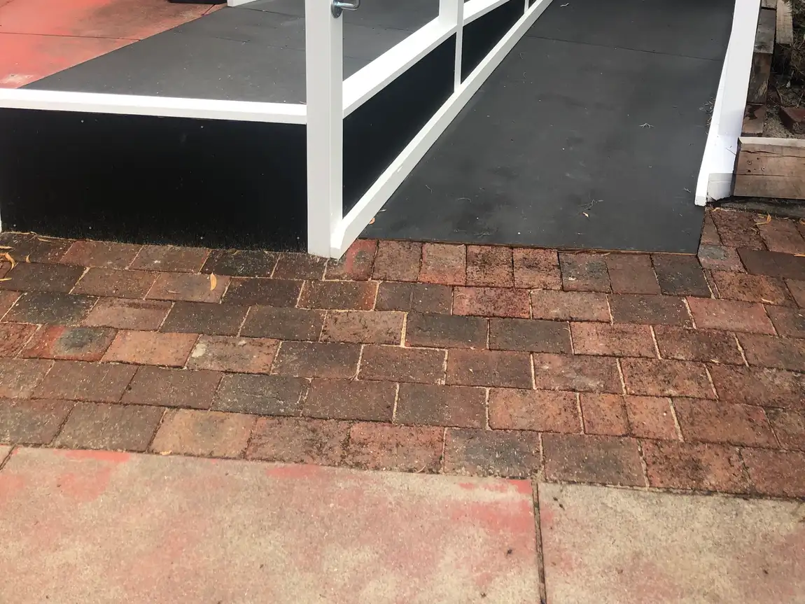 After: the same entry with a wheelchair ramp in place of the steps, giving a continuous level route to the door