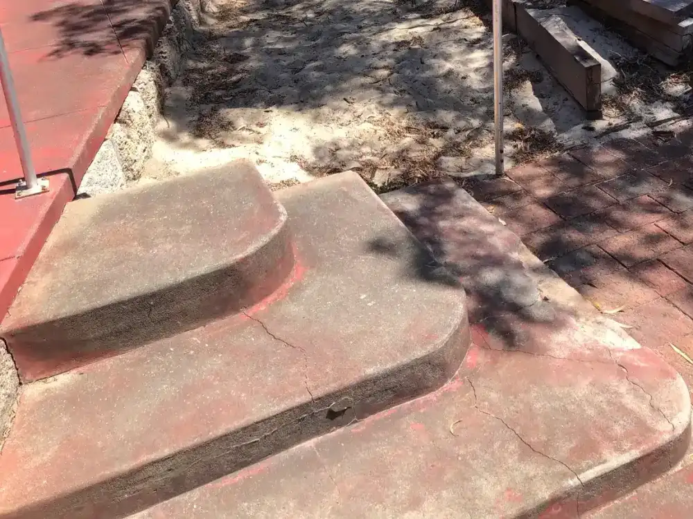 Before: worn concrete steps up to the entry of a Perth home, with a single handrail and no level way in